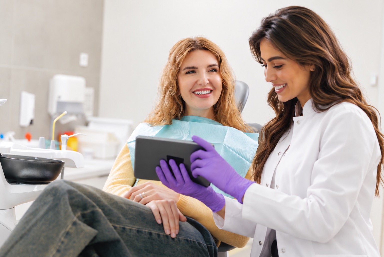 Smiling patient reviewing a tablet with her dentist